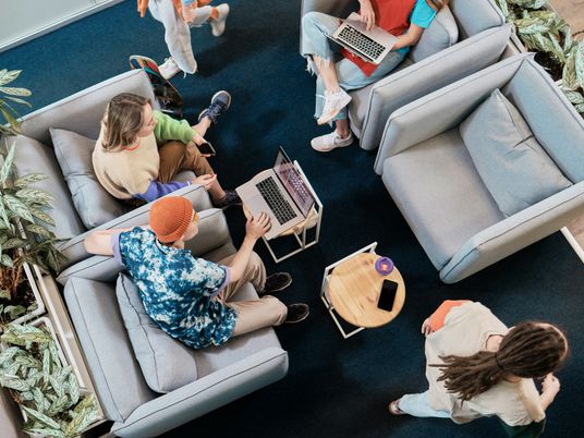 eine-gruppe-von-menschen-die-auf-sofas-in-einem-wohnzimmer-sitzen
