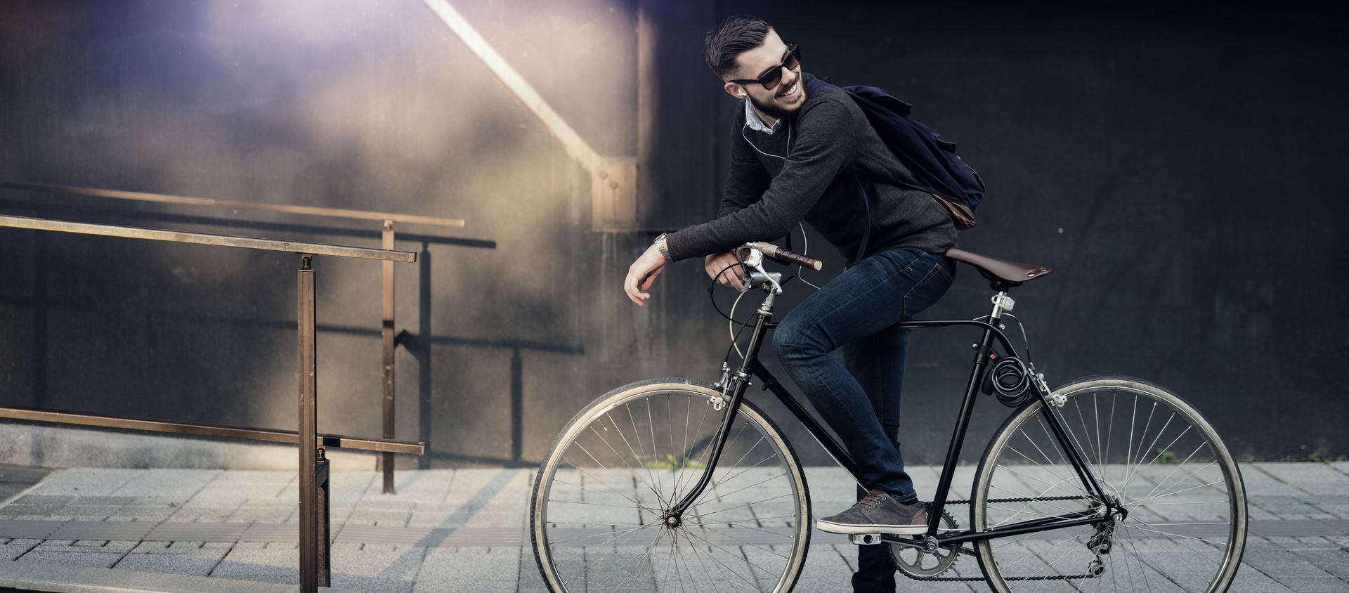 Ein Mann steht lässig auf seinem Fahrrad.